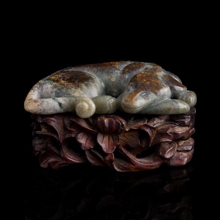 十八世紀或更早 玉雕臥狗(附硬木座) A Chinese jade dog, 18th century or earlier
