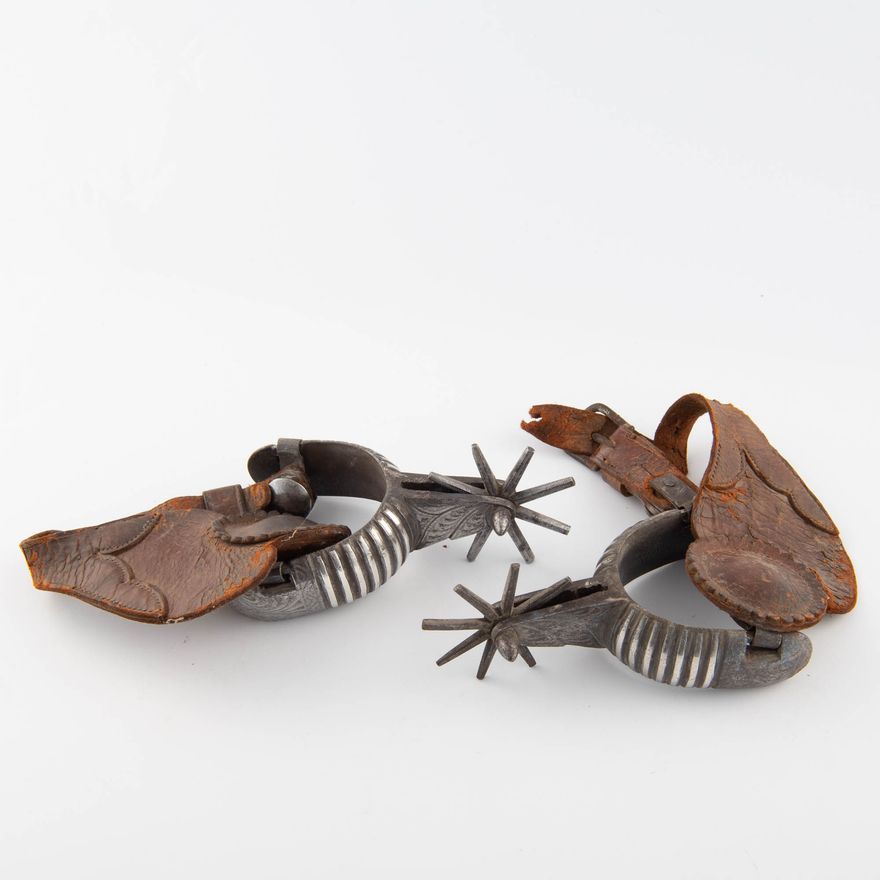 A pair of Mexican silver-inlaid iron spurs