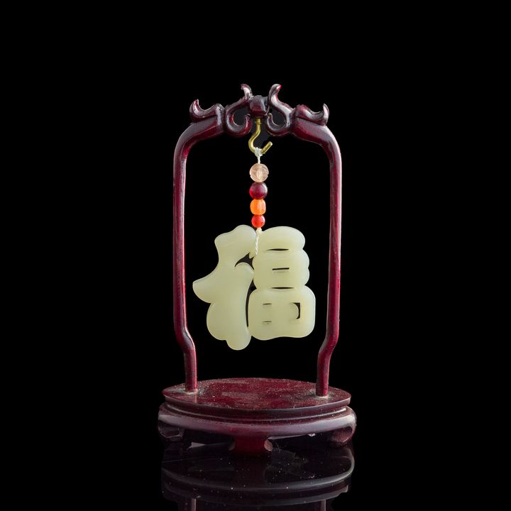 十九世紀早 白玉雕福字佩(附木架) A Chinese carved white jade 'fu' pendant, early 19th century