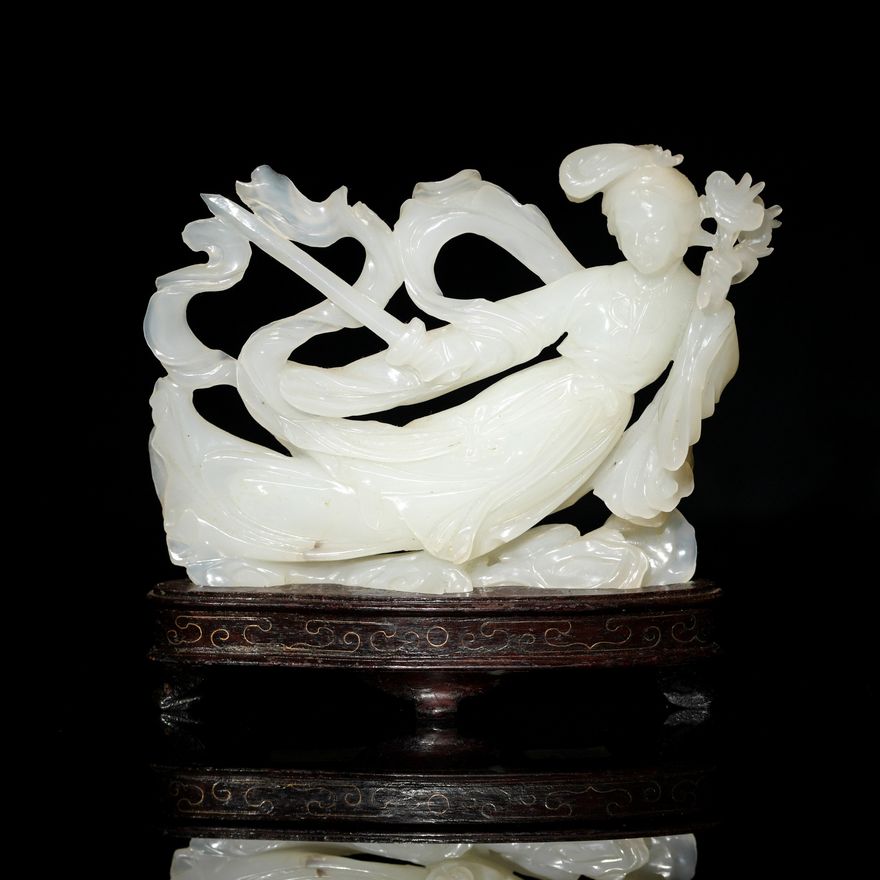 A Chinese white jade carving of a beauty holding a sword and lingzhi with wooden stand, Mid-20th century