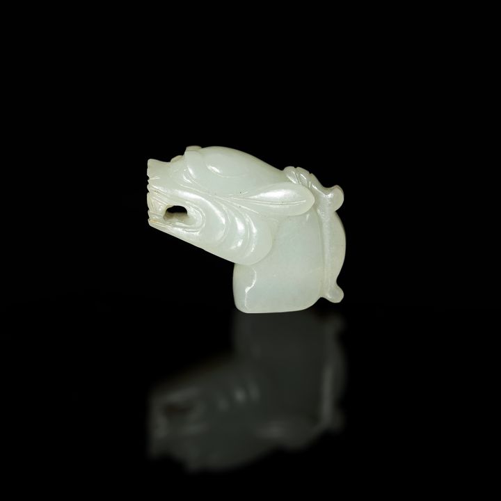 十八世紀 白玉雕獸頭掛墜 A Chinese carved white jade beast head toggle, 18th century