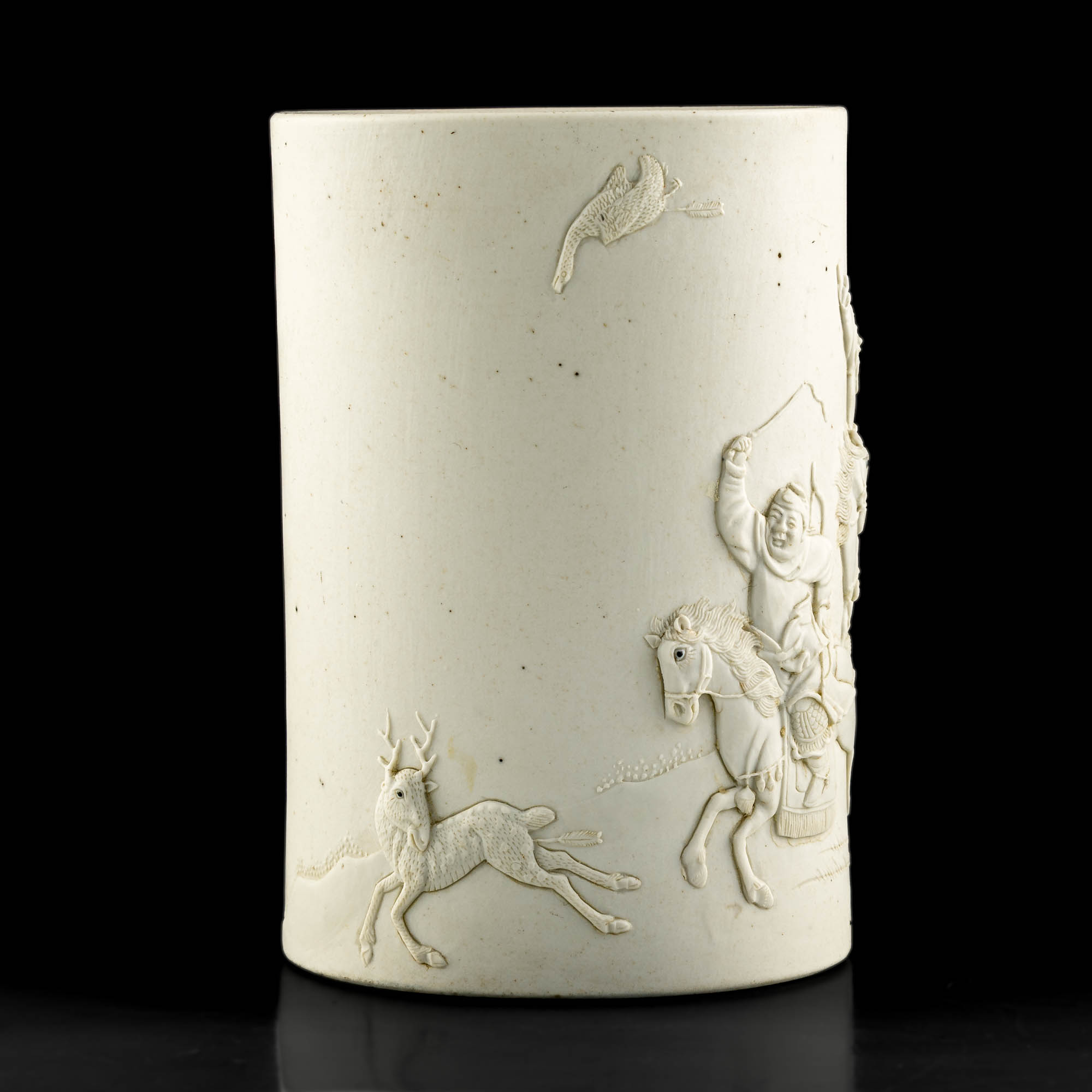 十九世紀王炳榮造生瓷狩獵圖筆筒A Chinese white-glaze brush pot with